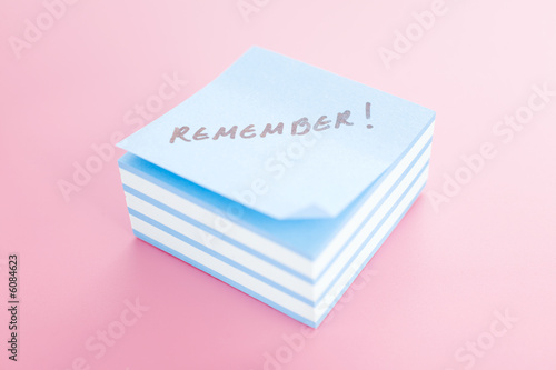 Pile of sticky notes with text over a pink table photo