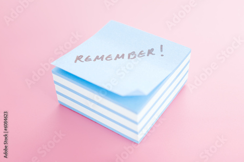 Pile of sticky notes with text over a pink table