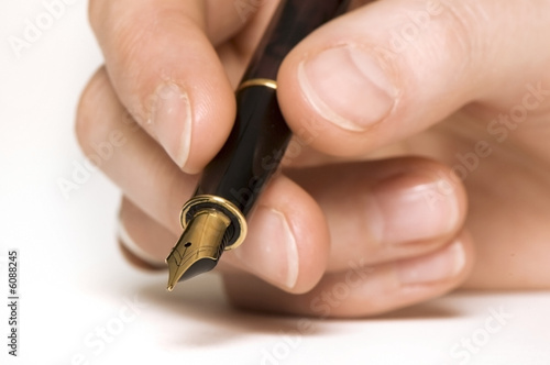 close up of a hand holding a pen. sharpness on pen.