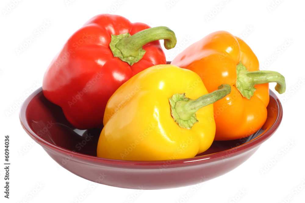 Red, yellow and orange bell peppers on plate
