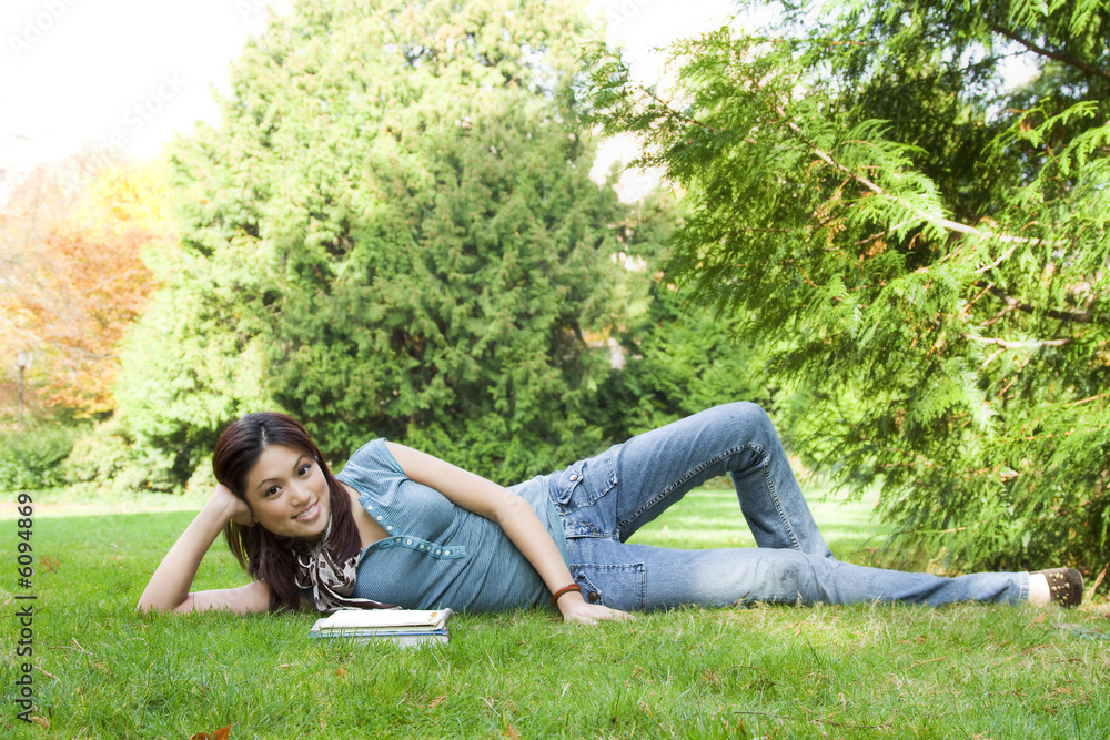 A beautiful college student studying at a park A beautiful college student studying at a park