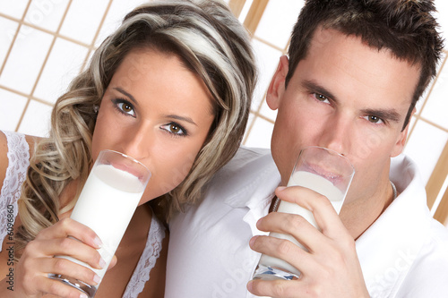 Young love couple drinking milk. Over white background  .