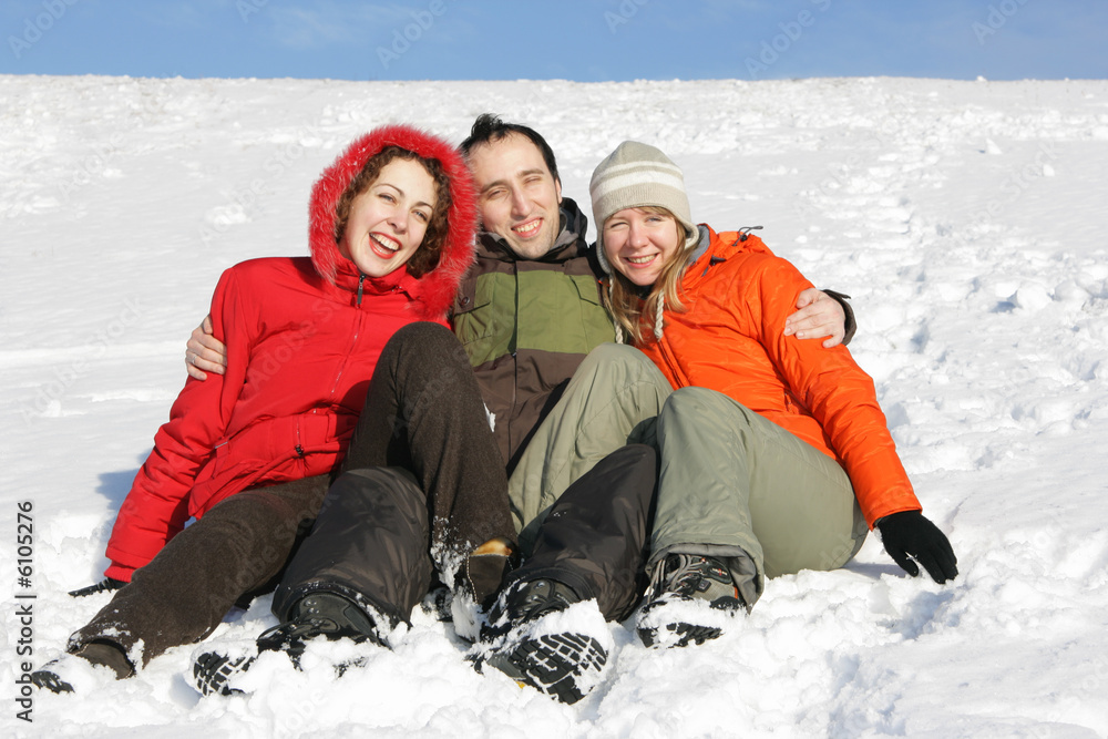 Two smiling woman and male have rest on snow