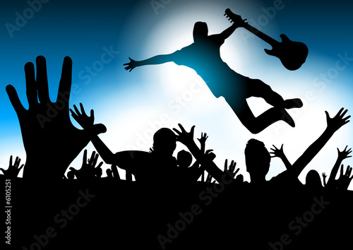 Music star jumping with the guitar in a concert