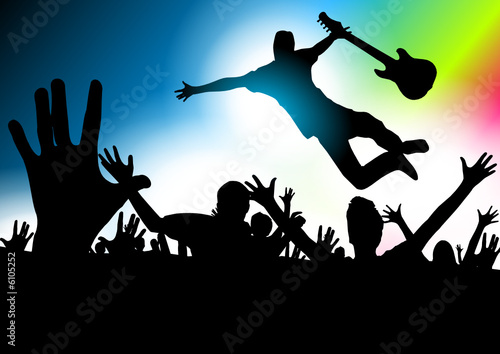 Music star jumping with the guitar in a concert