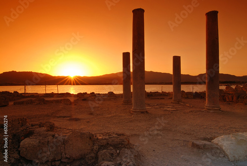 Sunset and pilars of ruins on Sardinian town of Nora photo