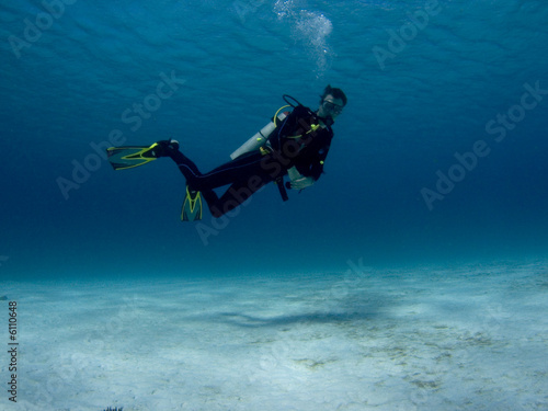 Diver over white sand in the Caribbean Sea