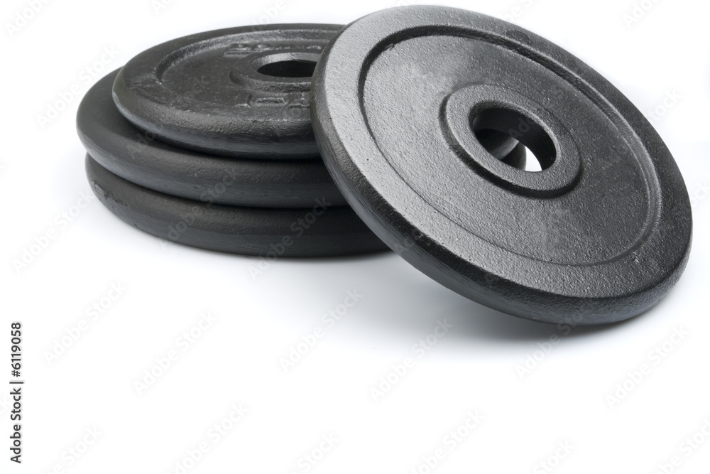 Stack of black weights on a white background. Horizontal shot. Stack of black weights on a white background. Horizontal shot.
