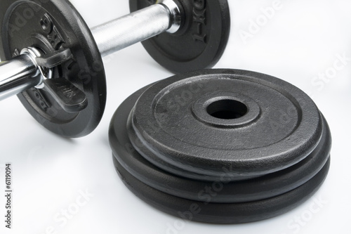 Stack of black weights on a white background. Horizontal shot.