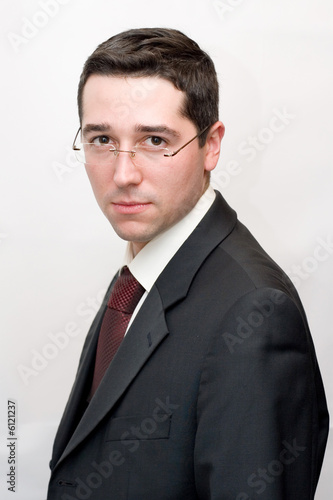 A businessman spectacled looks in a lens