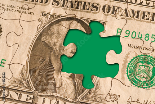 a nearly completed currency puzzle with one piece missing