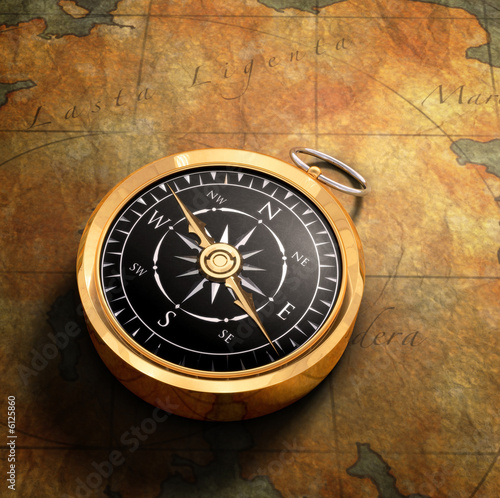 An old fashoned brass compass on a Treasure map background photo