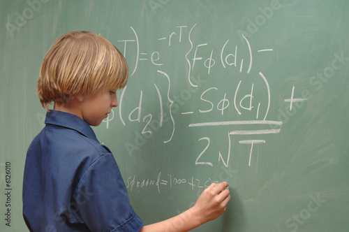 Nine year old boy doing advanced math on a chalkboard