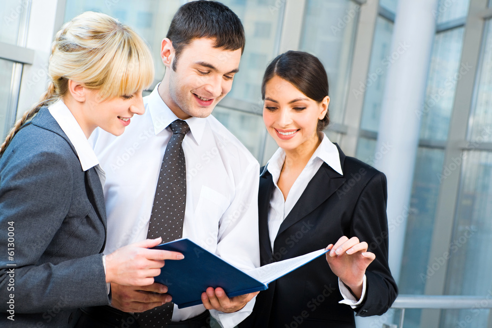 Portrait of happy business people looking at document Portrait of happy business people looking at document
