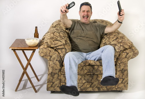 Sports fan on overstuff chair watching TV
