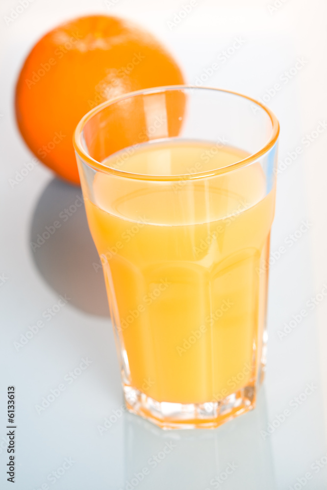 A glass of cold and refreshing orange juice and an orange A glass of cold and refreshing orange juice and an orange