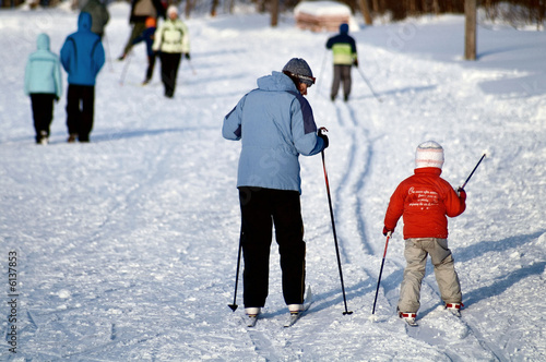 Mother teaches the daughter to ski.