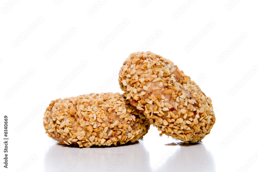 A pair of peanut covered donuts over white. A pair of peanut covered donuts over white.