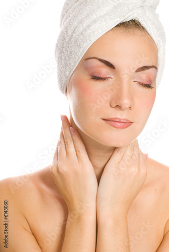 Young lovely lady applying moisturizer to her face