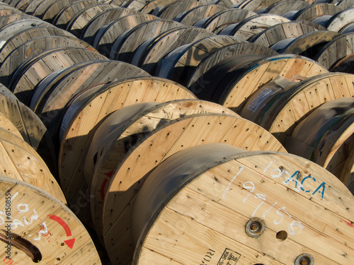wooden spools of wire in the yard of a electric utility company 