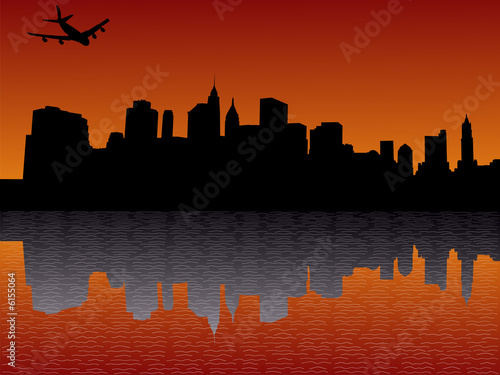plane flying over Lower Manhattan skyline at sunset