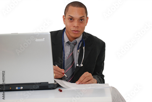 docteur remplissant une ordonnance a son bureau photo