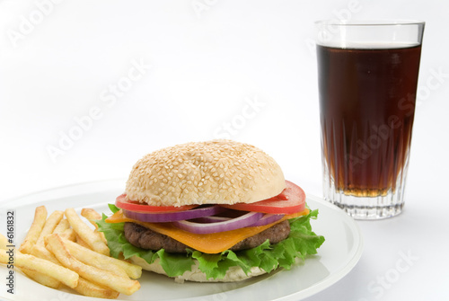 A burger meal with coke and fries on a white plate