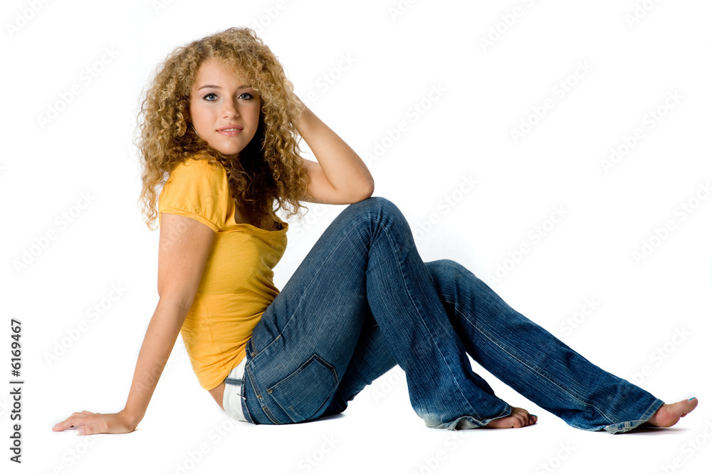 A happy teenage girl with curly hair on white background