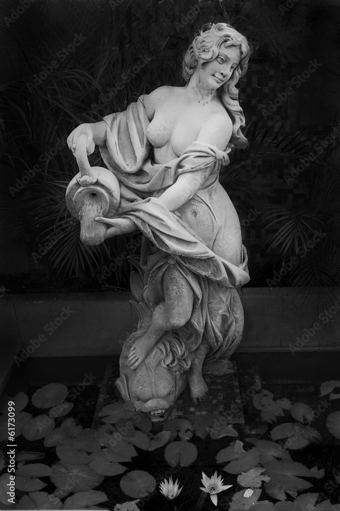Detail of fountain with female statue pouring water Detail of fountain with female statue pouring water