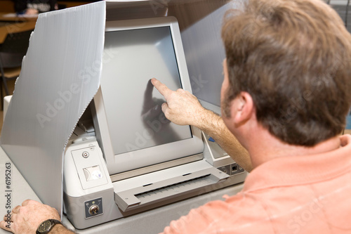 Slika na platnu Man voting on a new touch screen machine in Florida.