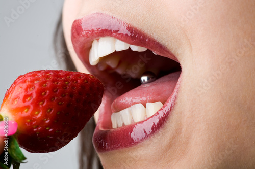 Mund beisst in Erdbeere - Zunge mit Piercing