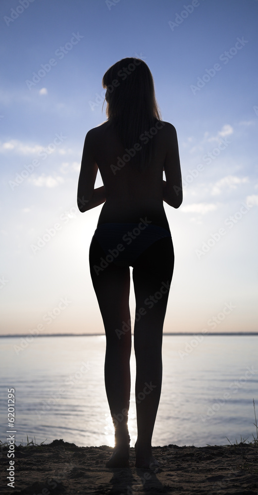 silhouette of young woman against summer sunset
