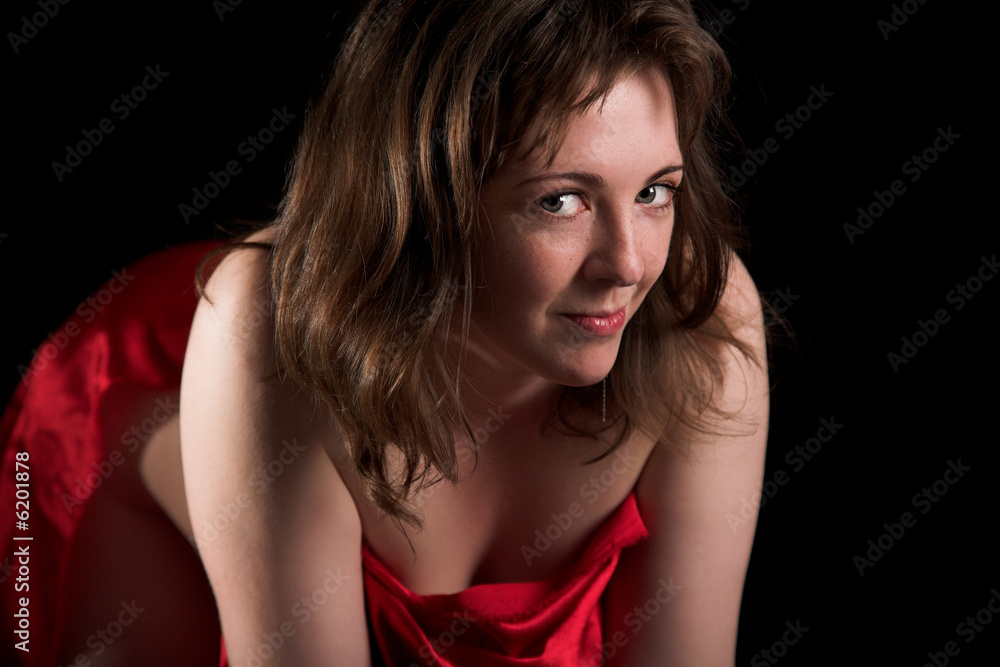 Young woman in red silk isolated in the black background Young woman in red silk isolated in the black background