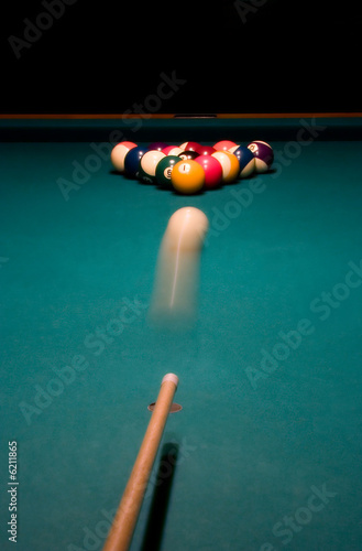 Shooting the white ball to break the racked billiard balls..
