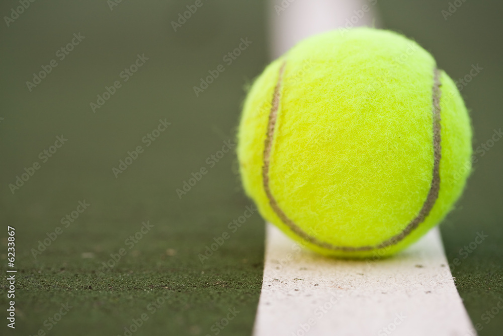 A closeup shot of a tennis ball in a tennis court