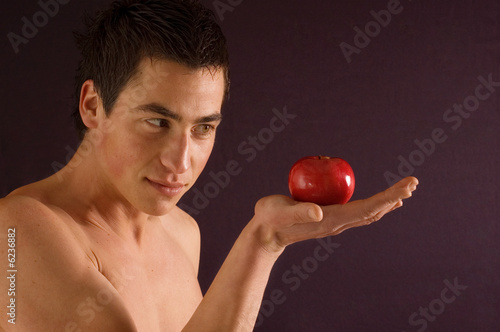 Young naked man holding red apple