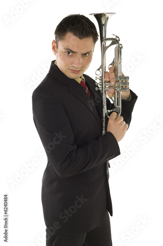 Man in suit holding a trumpet and posing. 