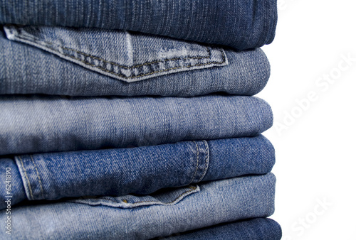 stack of blue jeans over white