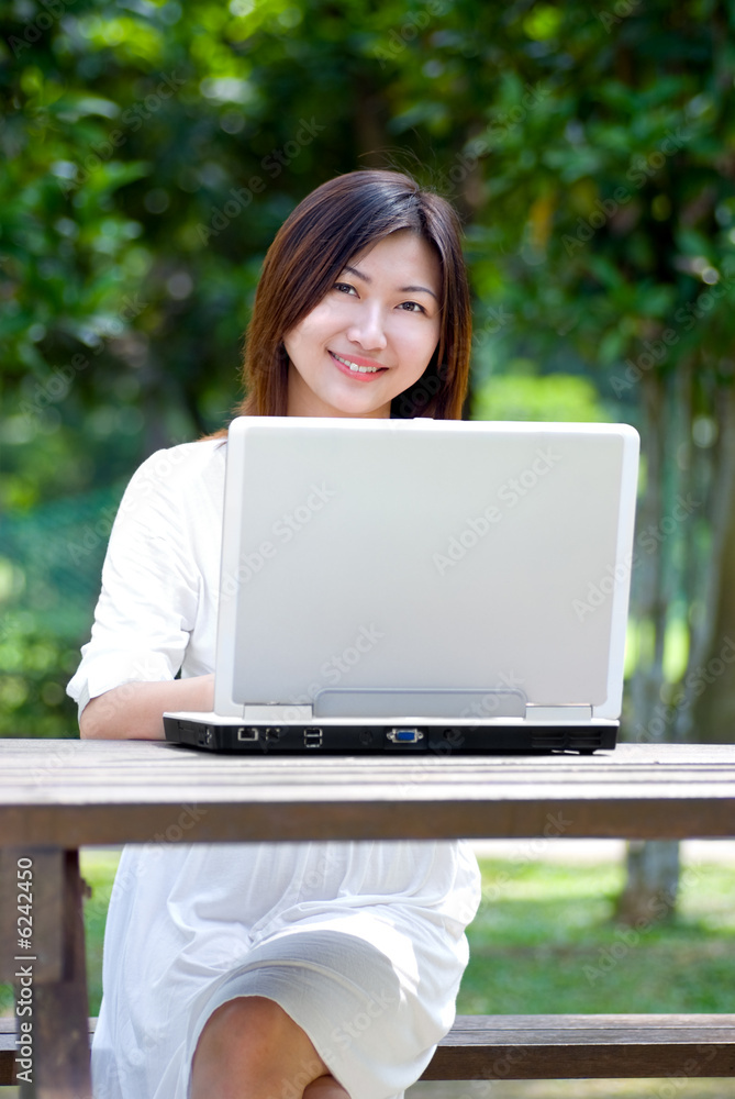 Women working on laptop at the park Women working on laptop at the park