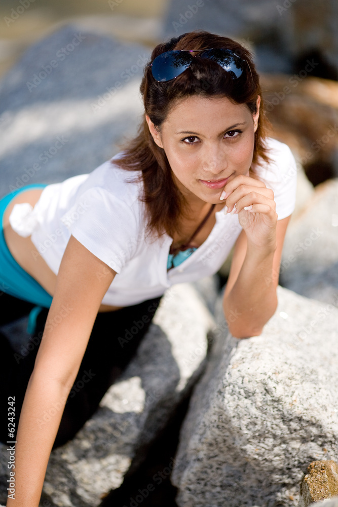 girl relaxing on the rocks by the beach girl relaxing on the rocks by the beach