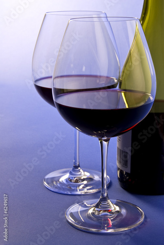 Two Glasses of Red Wine Beside a Bottle