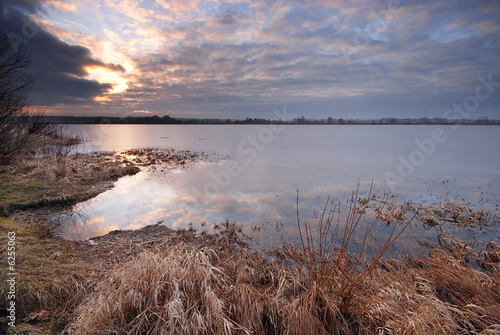 Fototapeta Naklejka Na Ścianę i Meble -  Ice melting on a lake at sunset