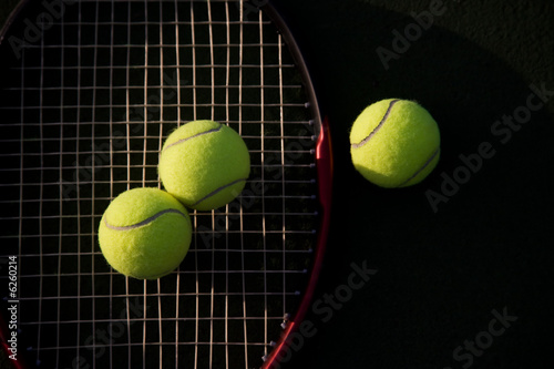 A shot of tennis racquet and tennis balls on a tennis court © arekmalang