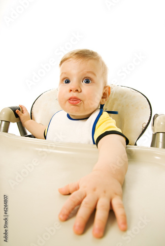 Hungry baby sitting on eating chair isolated on white background