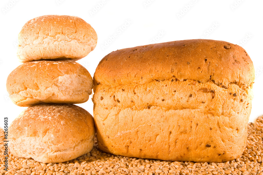 Three rolls and loaf on bed of wheat Three rolls and loaf on bed of wheat