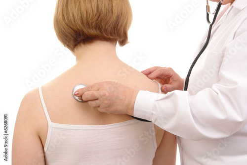 Family doctor examining female patient using stethoscope