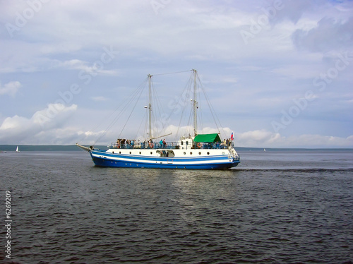 Single yacht on the sea waves under clouds