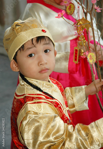 young chinese kid wearing traditional costume and hat