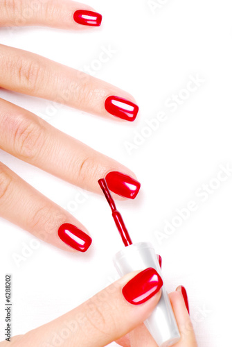 Murais de parede Manicurist applying red nail polish on female fingers.