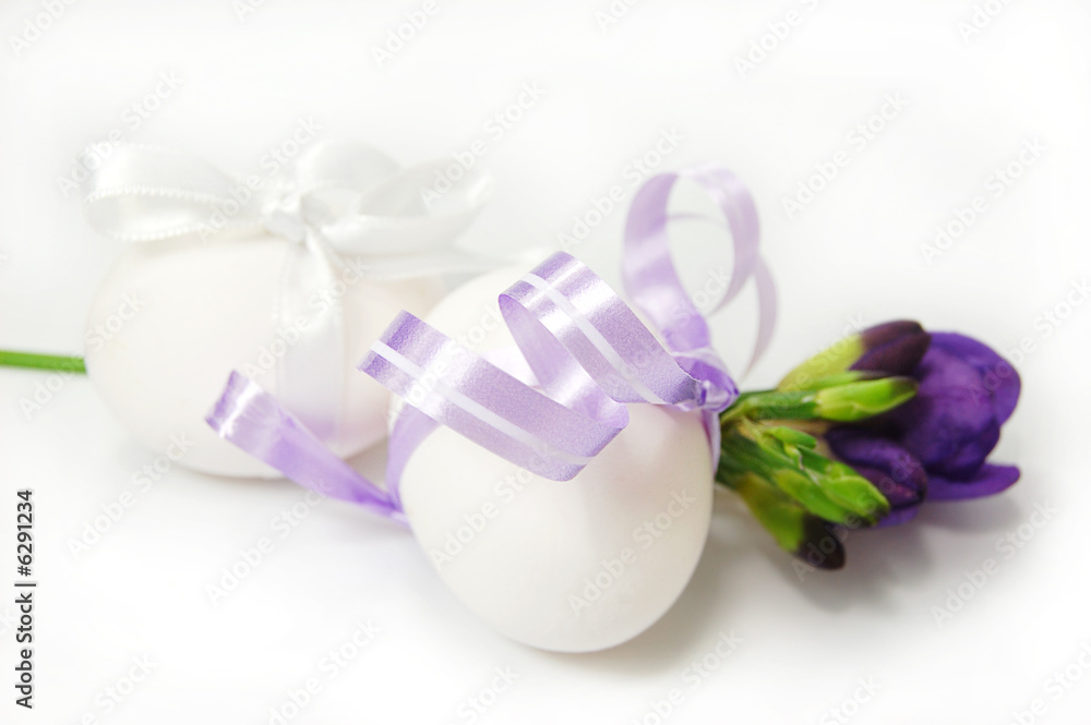 Two white eggs and freesia isolated on white Two white eggs and freesia isolated on white